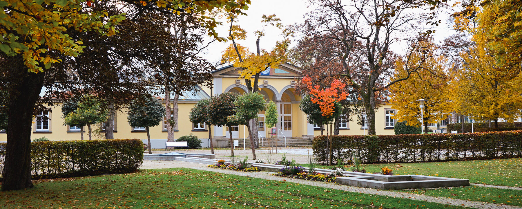 Der Kurpark besticht durch seine weitläufigen Grünflächen, gepflegten Blumenbeete und die idyllische Atmosphäre, die zum Entspannen und Spazieren einlädt