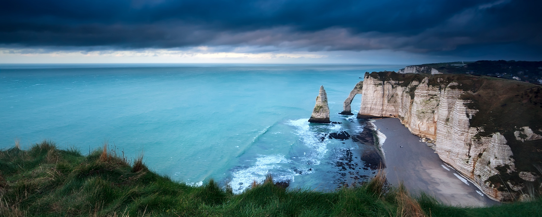 Die berühmten Felsbögen von Étretat mit der Nadelspitze "Aiguille" ragen dramatisch ins Meer und bieten atemberaubende Ausblicke