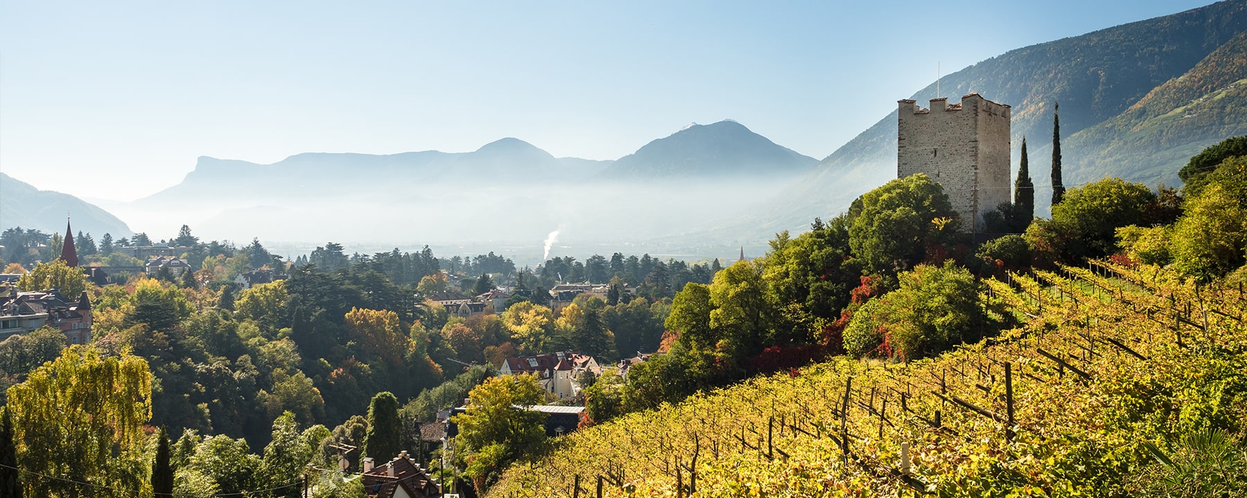 Die Wanderwege rund um Meran führen durch mediterrane und alpine Landschaften, vorbei am historischen Pulverturm, der einen weiten Blick über die Stadt und das Tal bietet