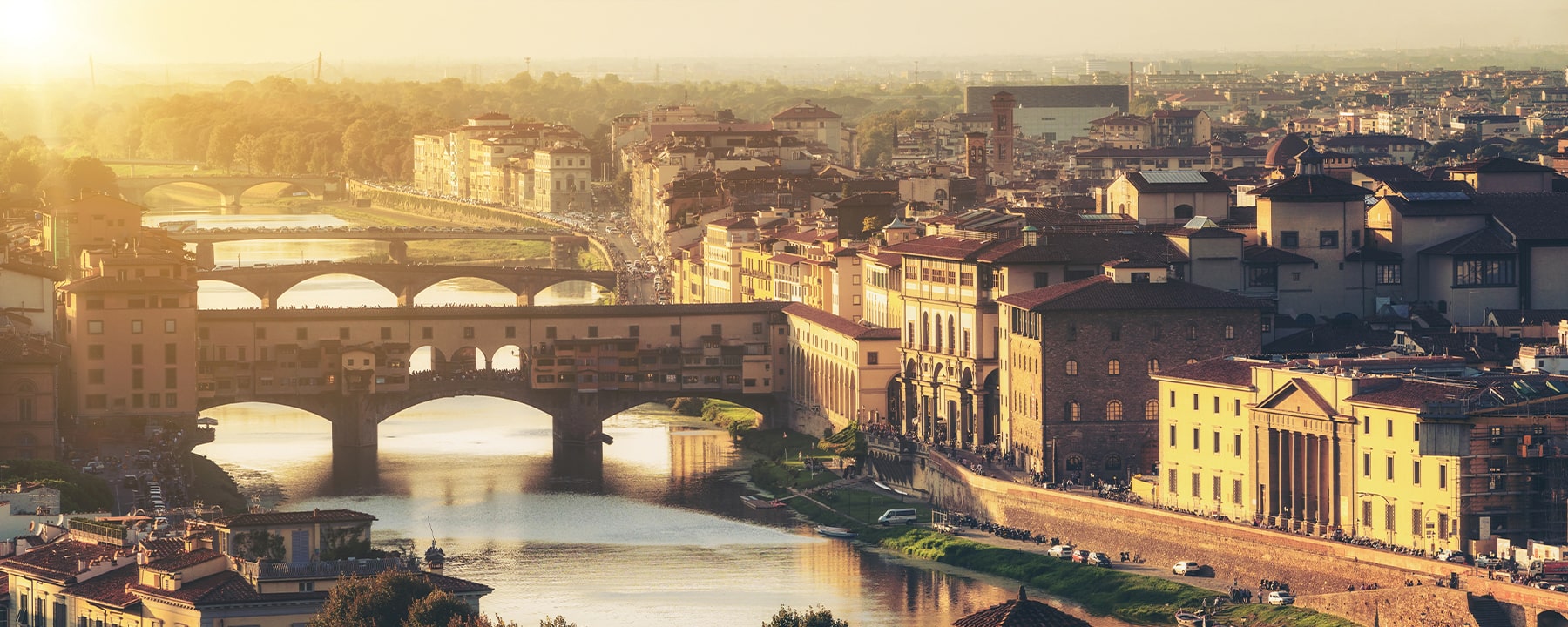 Florenz liegt malerisch am Ufer des Arno, der die Stadt durchzieht und die berühmte Ponte Vecchio überspannt, eine historische Brücke, die seit dem Mittelalter mit kleinen Goldschmiedegeschäften gesäumt ist