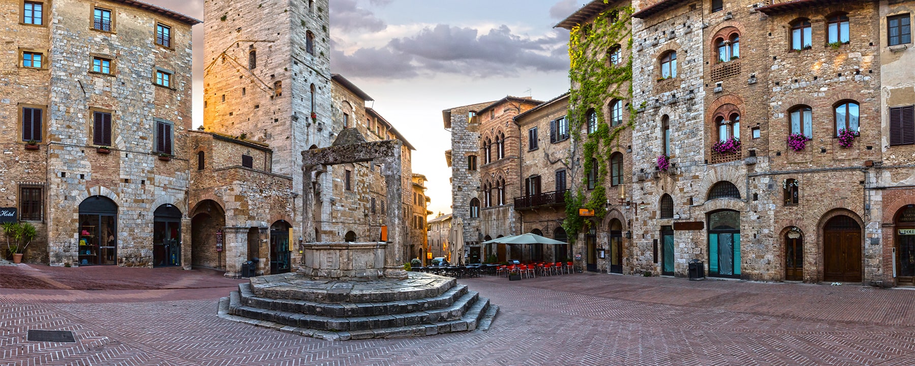 Die Piazza della Cisterna in San Gimignano, umgeben von mittelalterlichen Türmen und Palazzi, war einst Marktplatz und Treffpunkt und ist heute ein beliebter Ort, um die historische Atmosphäre der Stadt zu genießen