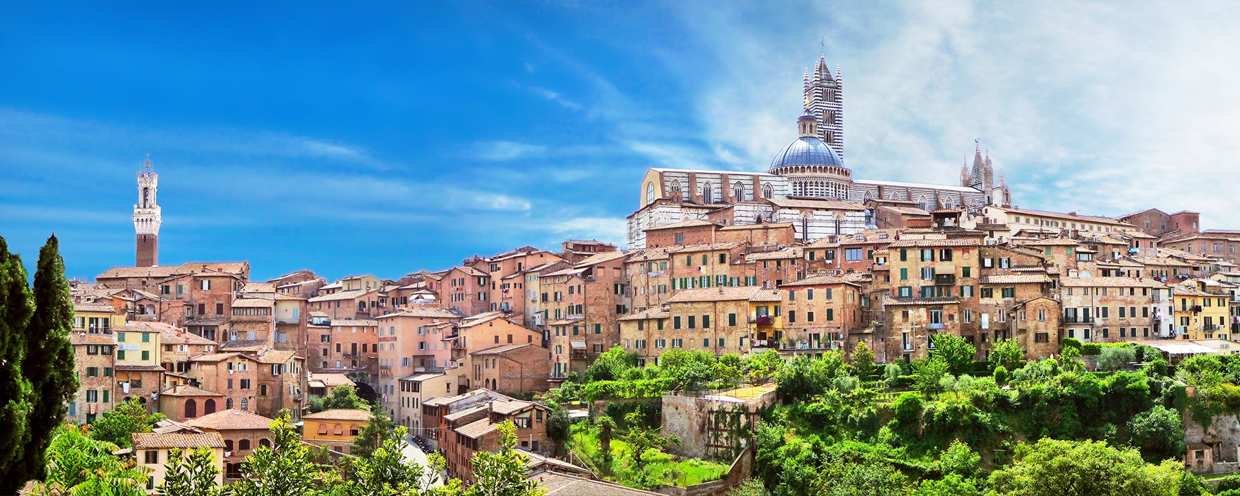 Siena thront auf drei Hügeln, und der majestätische Dom von Siena, mit seiner markanten Marmorarchitektur, überblickt die Stadt und die umliegende toskanische Landschaft