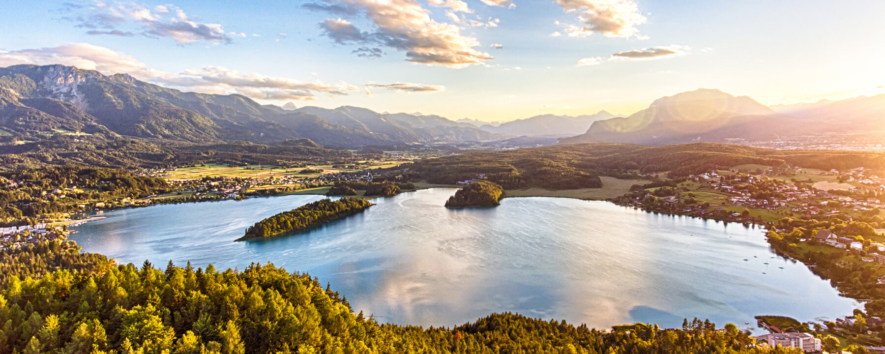 Der Faaker See ist bekannt für sein türkisfarbenes Wasser und bietet zahlreiche Freizeitmöglichkeiten wie Schwimmen, Segeln und Wandern in einer idyllischen Alpenkulisse