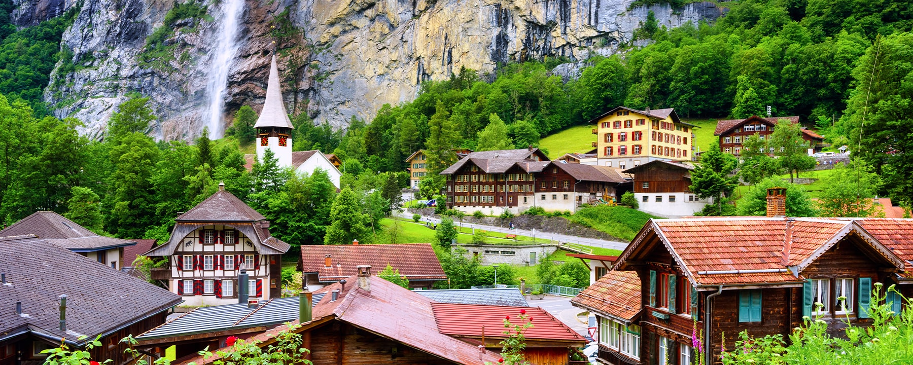 Die Holzhäuser in Lauterbrunnen mit ihren traditionellen Schindeldächern fügen sich harmonisch in die Naturkulisse des Tals ein und vermitteln den Charme eines ursprünglichen Alpendorfs