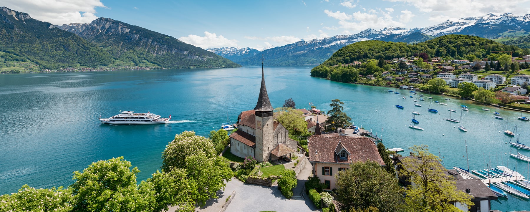 Der Thunersee, umgeben von malerischen Bergen und charmanten Uferorten, lädt mit seinen klaren, blauen Wassern zum Segeln, Schwimmen und Entspannen ein