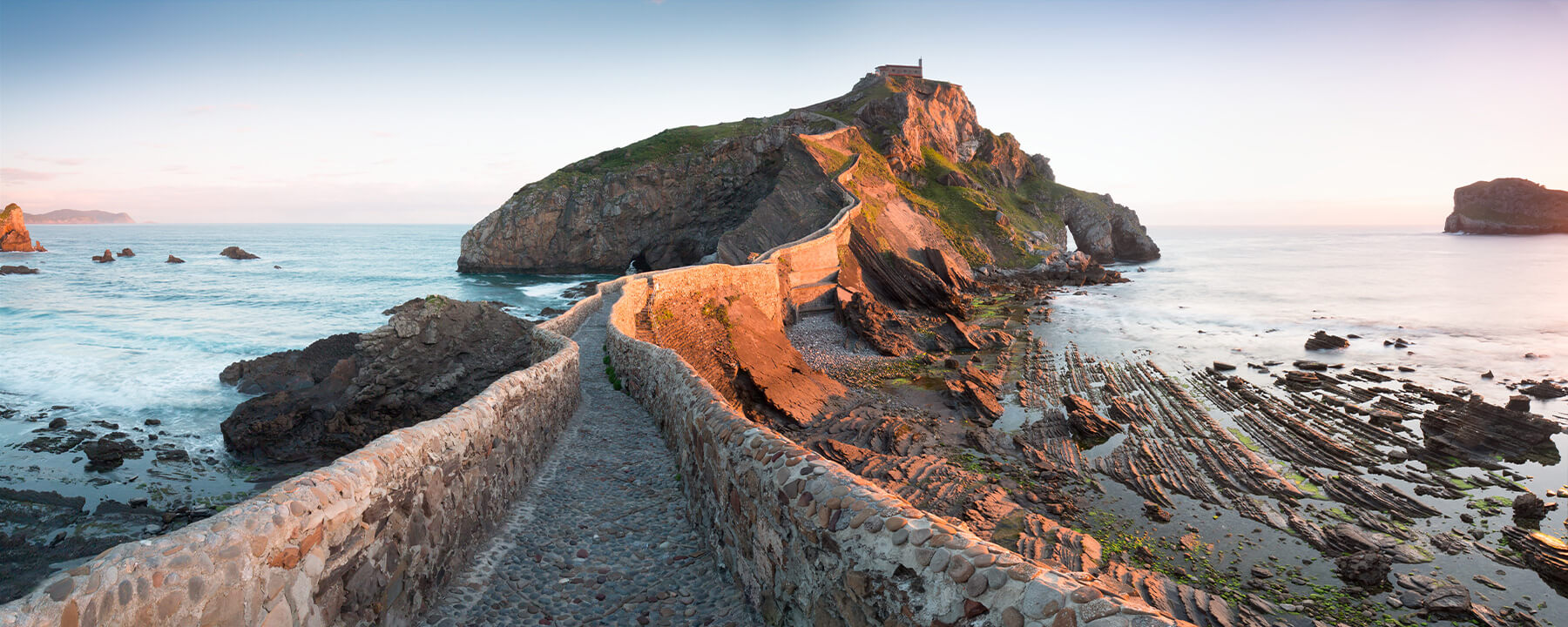 San Juan de Gaztelugatxe ist eine kleine Insel an der Küste des Baskenlands und begeistert mit ihrer malerischen Kapelle, die über eine kurvenreiche Steintreppe erreichbar ist